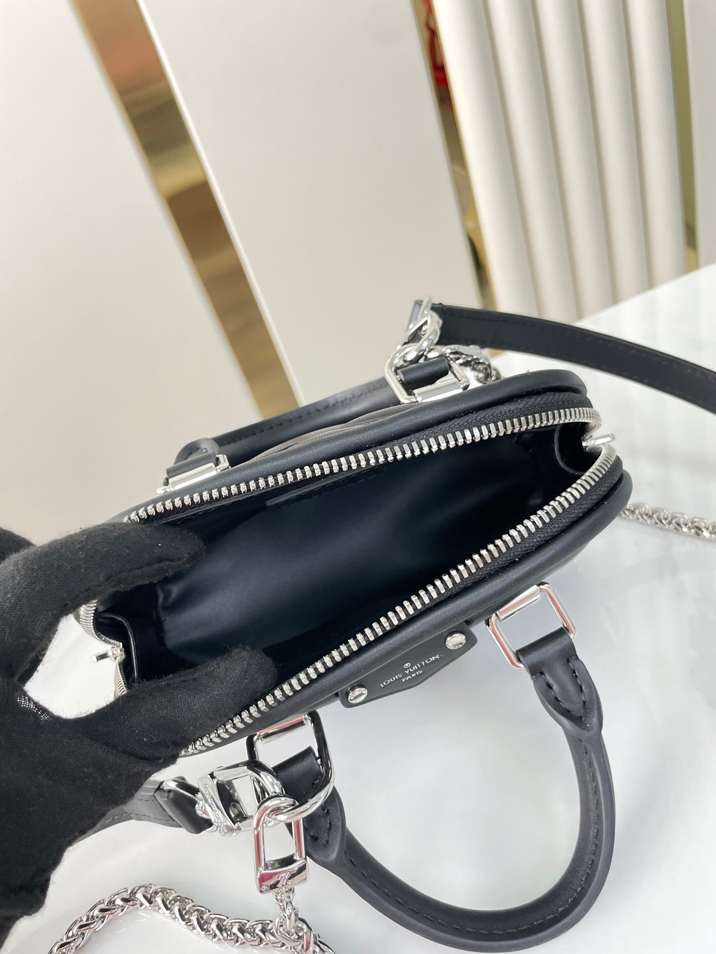 NANO ALMA 18 IN SCHWARZEM GESTEPPTES LAMMLEDER MIT GOLDENEN UND SILBERNEN BESCHLÄGEN