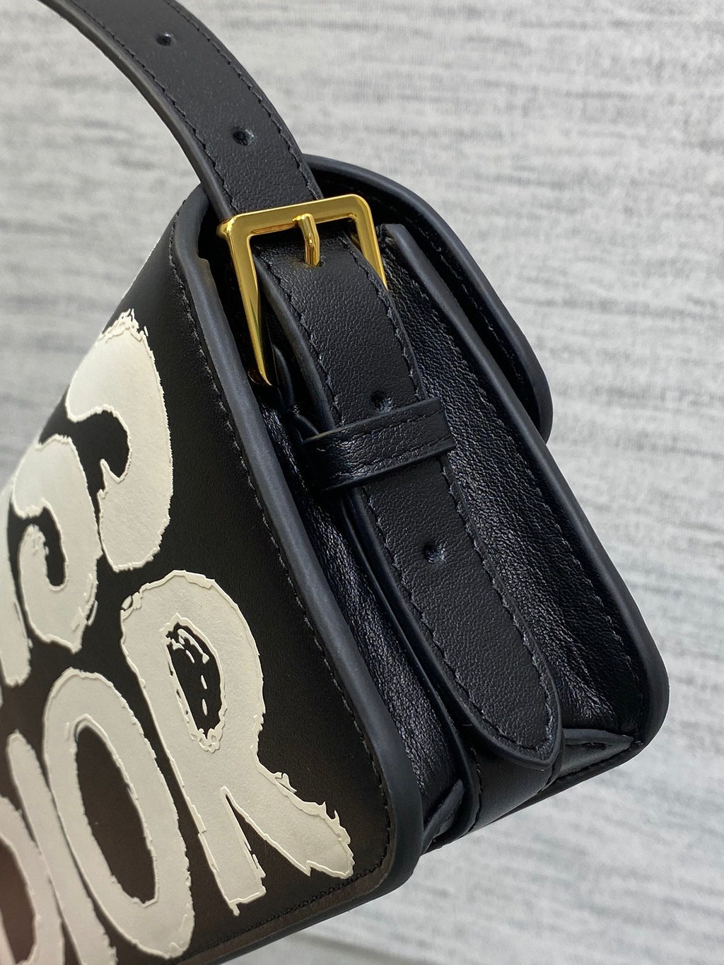 KLEINE 22-KLAPPENTASCHEN AUS SCHWARZ-WEISSEM LAMMLEDER MIT GOLDENEN BESCHLÄGEN