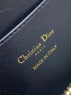 KLEINE 22-KLAPPENTASCHEN AUS SCHWARZ-WEISSEM LAMMLEDER MIT GOLDENEN BESCHLÄGEN