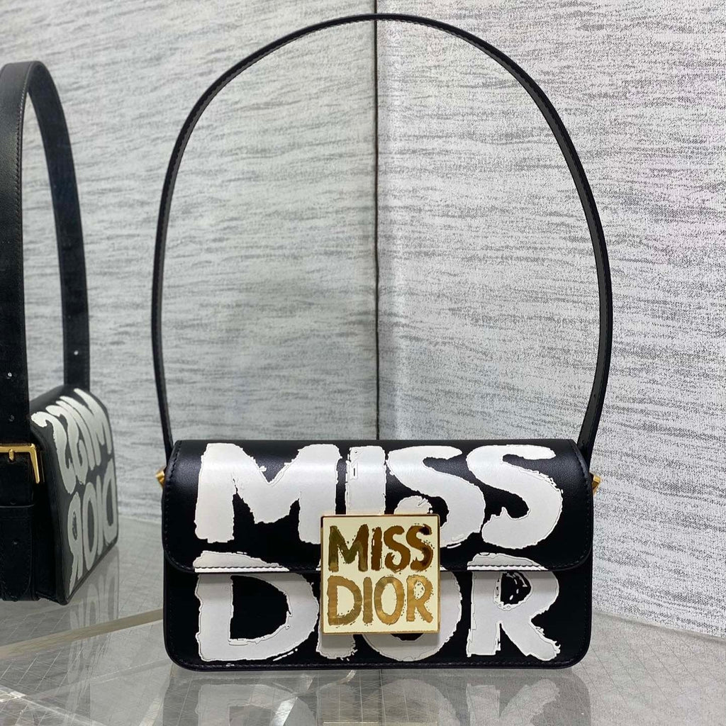 KLEINE 22-KLAPPENTASCHEN AUS SCHWARZ-WEISSEM LAMMLEDER MIT GOLDENEN BESCHLÄGEN